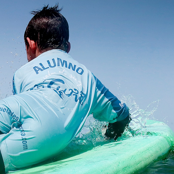 menor en el agua durante clase de surf en surf camp