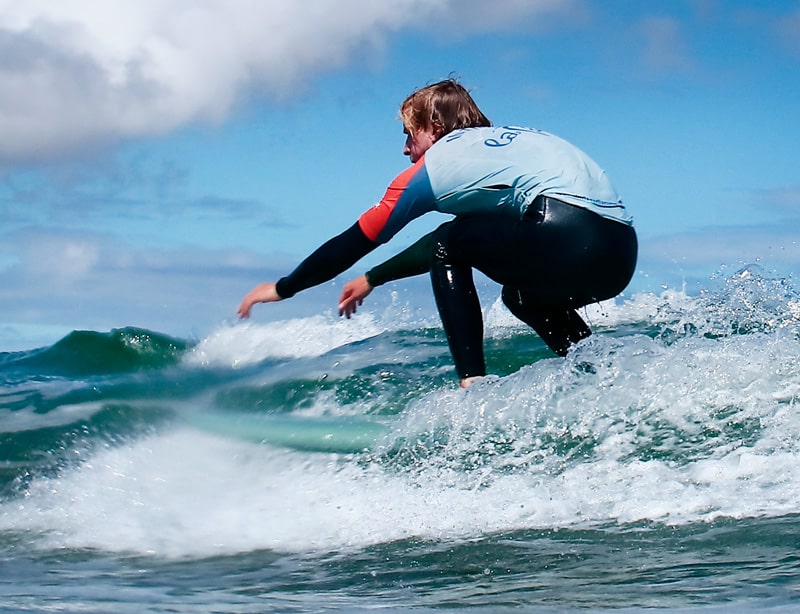 Monitor de surf en clase cogiendo una ola