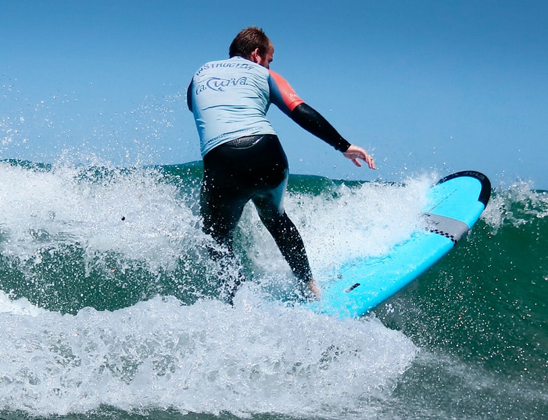 Instructor surfeando en clase de surf
